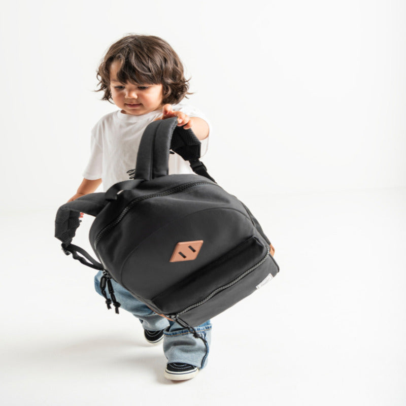 Child holding a Herschel backpack.