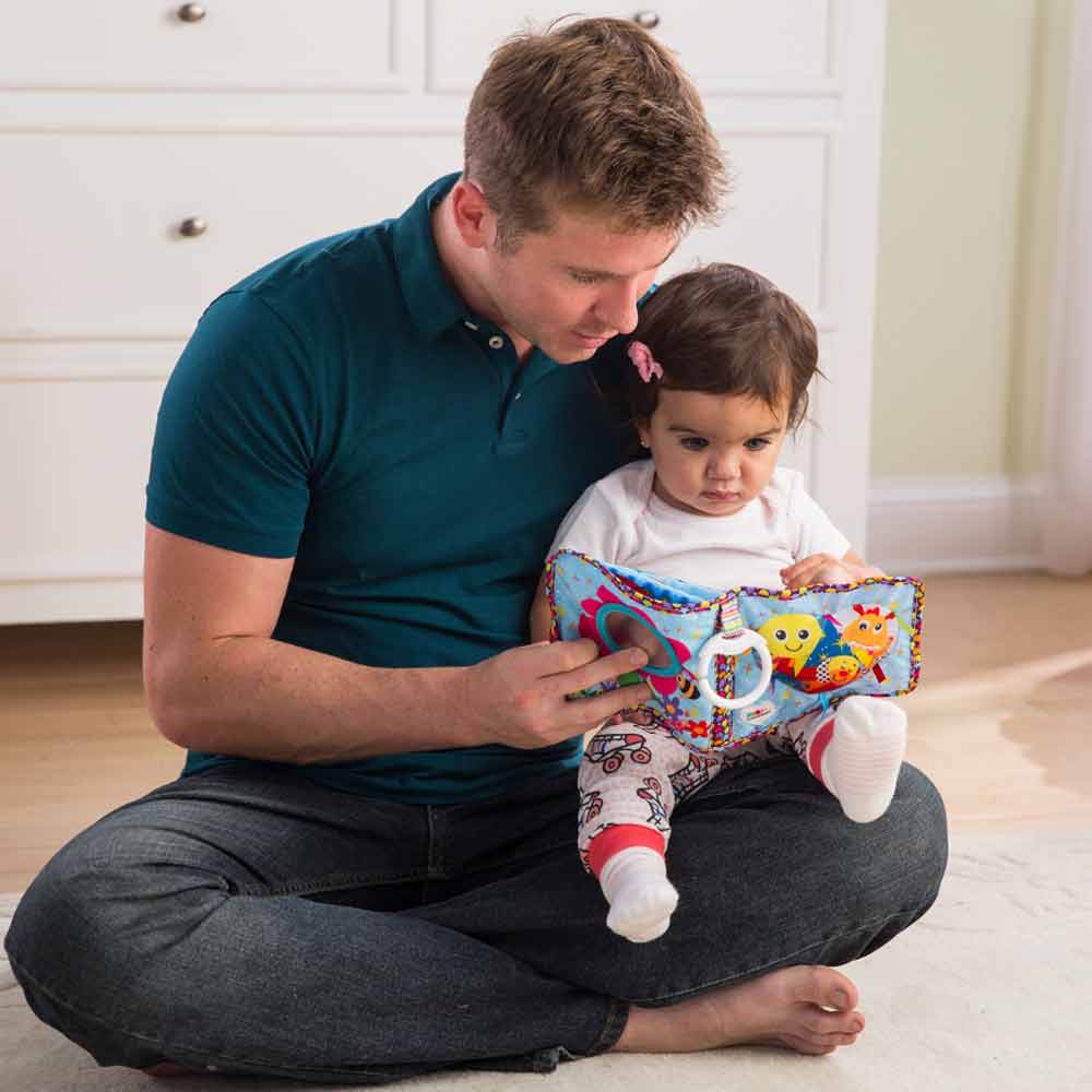 A father and a little girl bonding over story time with lamaze's Fun with Feelings book.