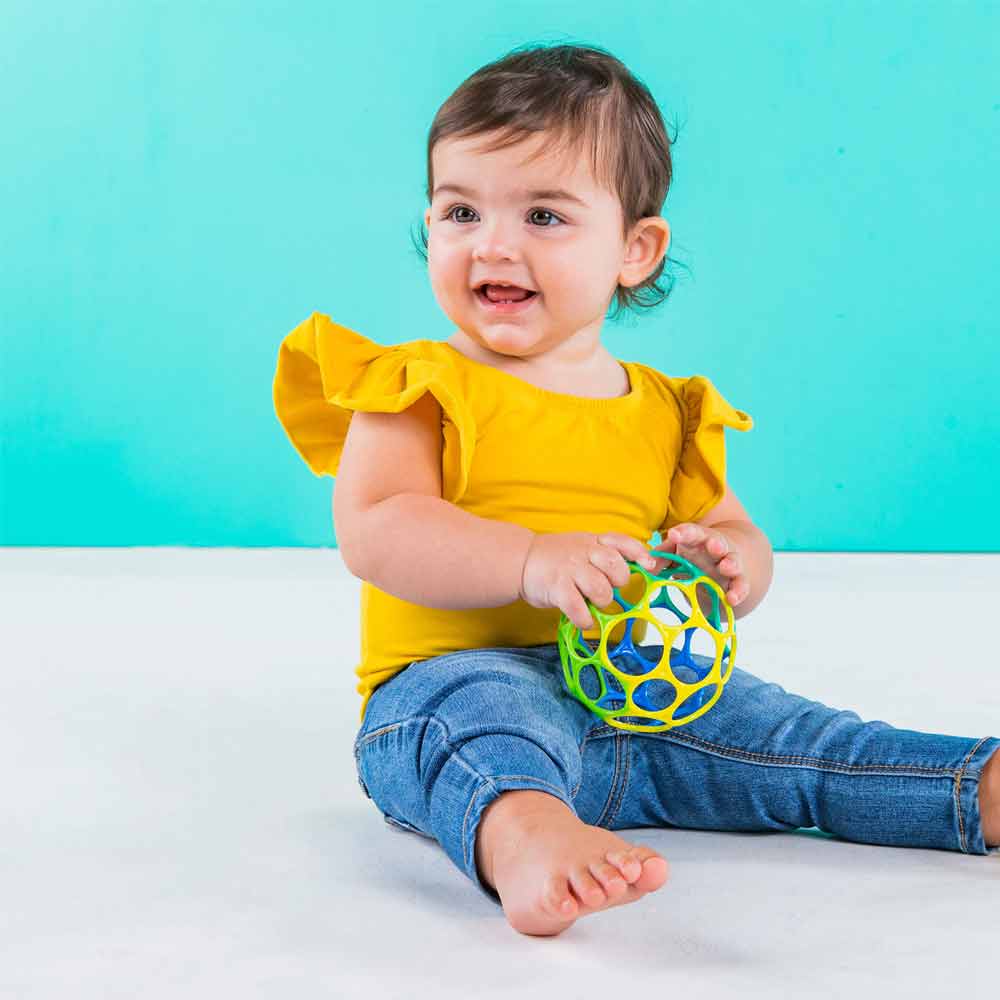 A baby playing with the 4-inch Oball.