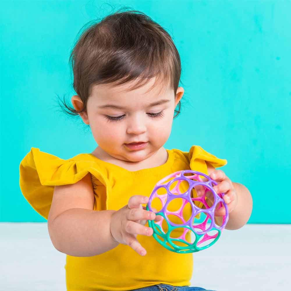 A baby playing with the 4-inch Oball.