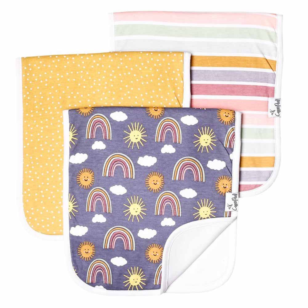 3 burp cloths with different patters, one with rainbows, sunshine and clouds, a yellow one with white polka dots and a striped one.