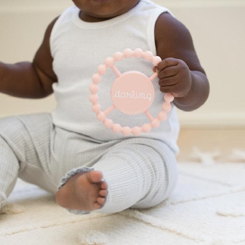 A baby playing with Bella Tunno's "Darling" teether.