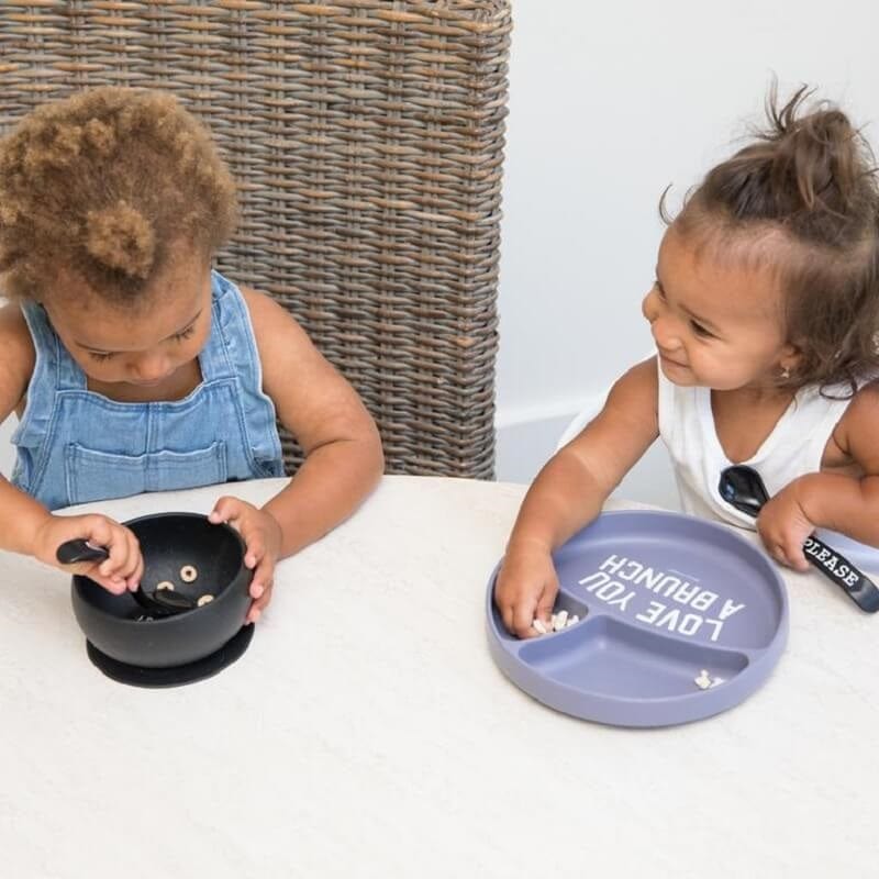 Two little children enjoying their dinnerware by Bella Tunno.